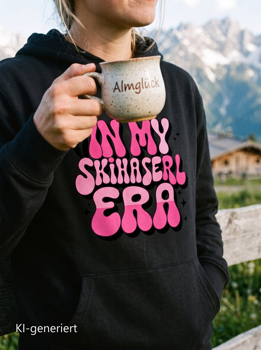 Frau im Hoodie In my Skihaserl Era an der Almhütte