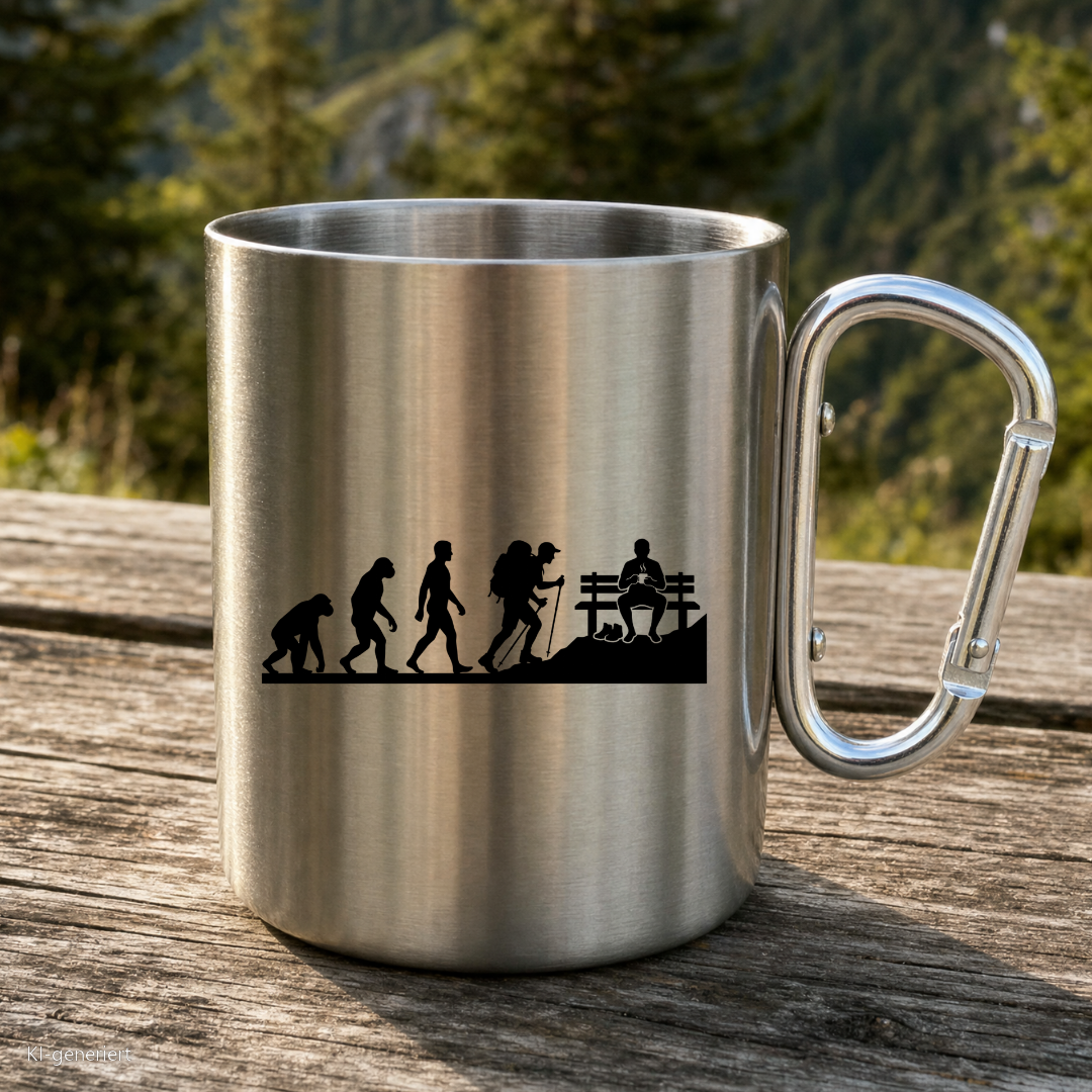 Karabinertasse von Kraxelgaudi mit Evolution des Wanderers steht auf Holz vor Bergkulisse