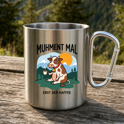 Karabinertasse von Kraxelgaudi mit Kuh und Spruch Muhment mal steht auf Holz vor Bergkulisse