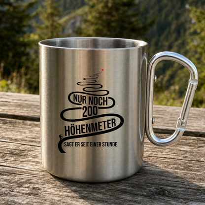 Karabinertasse von Kraxelgaudi mit Spruch Nur noch 200 Höhenmeter steht auf Holz vor Bergkulisse