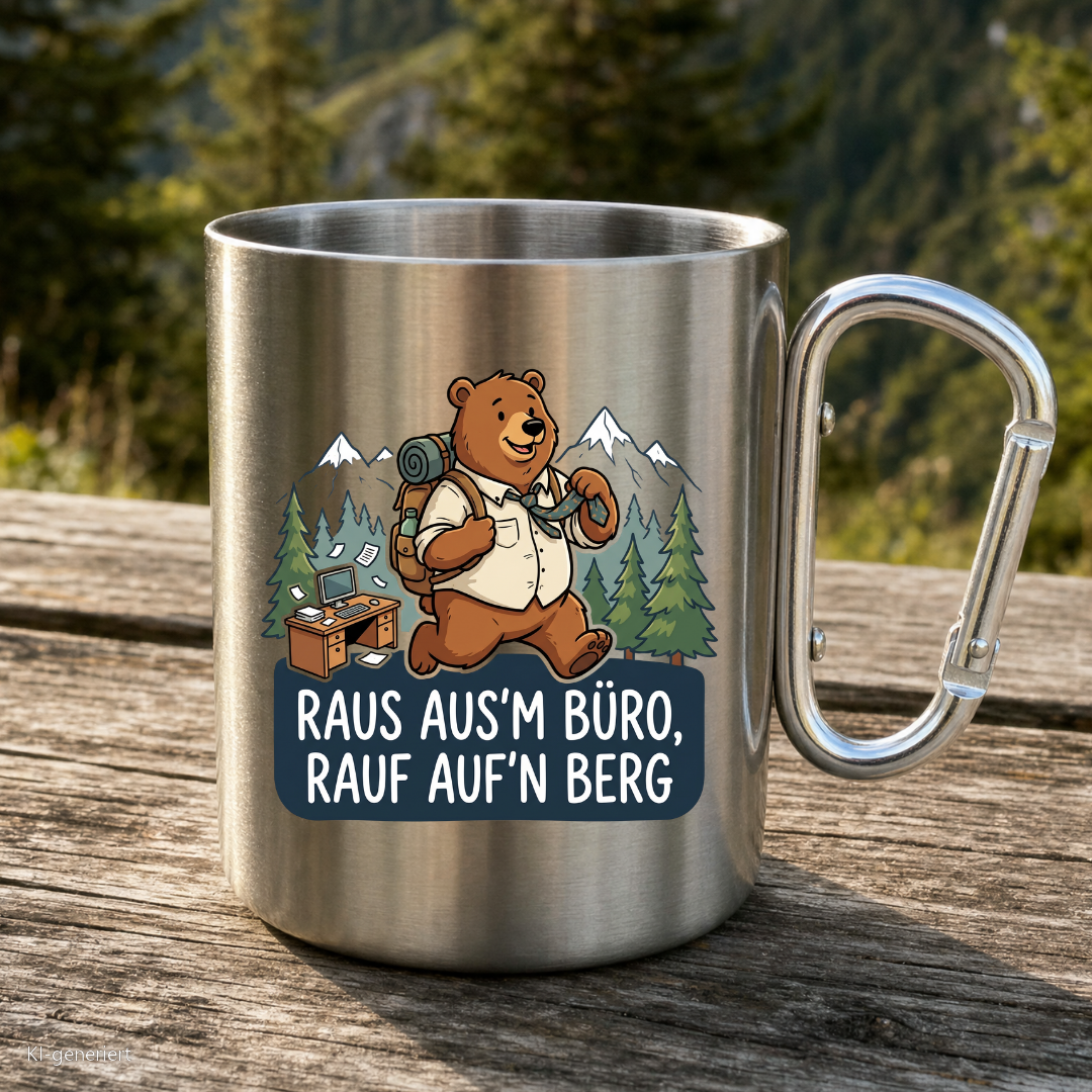 Karabinertasse von Kraxelgaudi mit Bär und Spruch Raus ausm Büro rauf aufn Berg steht auf Holz vor Bergkulisse