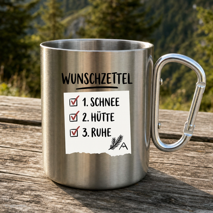 Karabinertasse von Kraxelgaudi mit Wunschzettel Motiv steht auf Holz vor Bergkulisse
