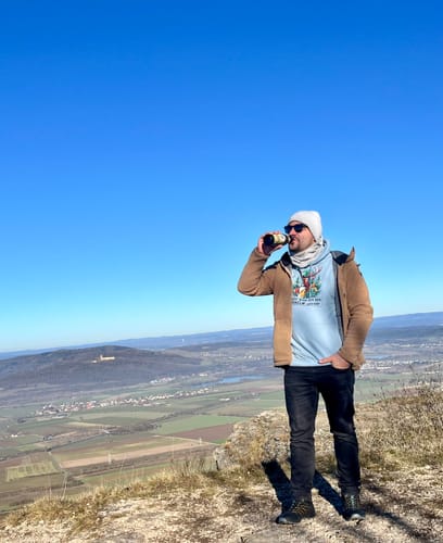 Kunde mit Fernglas auf einer Anhöhe